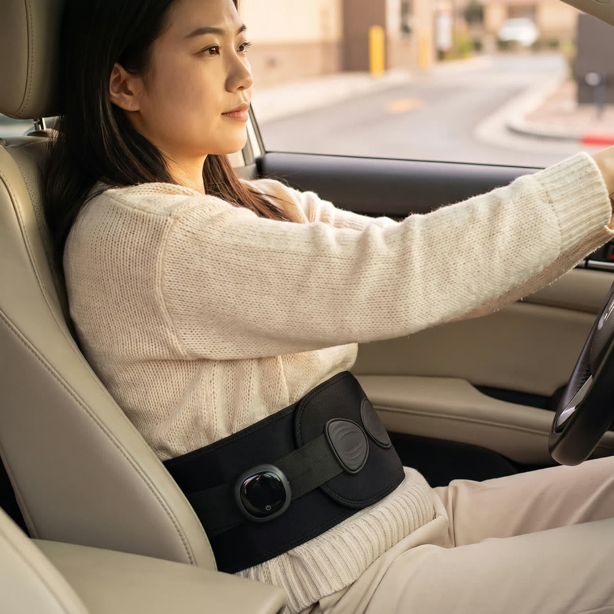 A woman driving with the Unknot Heat Belt on under her seatbelt